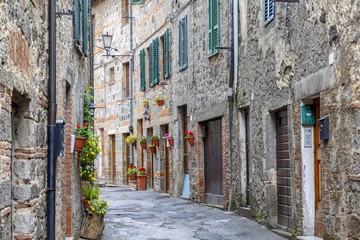 Fototapeta na wymiar Picturesque alley with flowers in an old Italian city