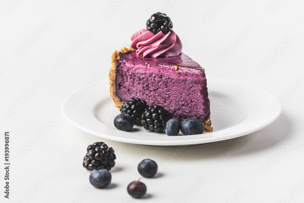 Wall mural close up view of blueberry cake with fresh berries on plate isolated on white