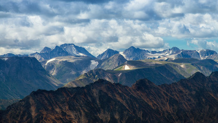 Fototapeta na wymiar High mountains range against cloudy sky, abstract background