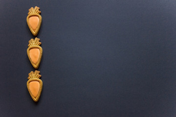 Ginger cookies in the shape of a carrot on black backgraund.