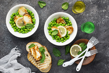 Green young peas, cheese haloumi, lemon. orange salad with slices of bread. Top View