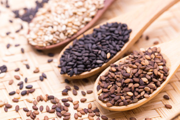 white sesame in wooden spoon on sesame background.