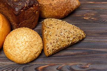 Bakery background, bread assortment on black wooden backdrop. Top view with copy space