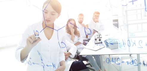 view through the transparent Board. female scientist makes a rep