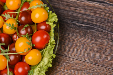 Cherry tomatoes with arugula  and  in a glass plate