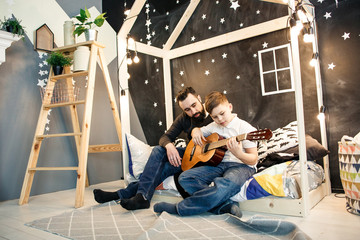 Man and boy with guitar at home