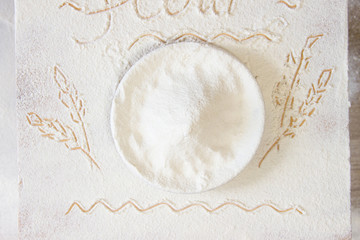 Plate with flour on floured table. Hand-drawn picture of ears of wheat. Simple folk ethnic style