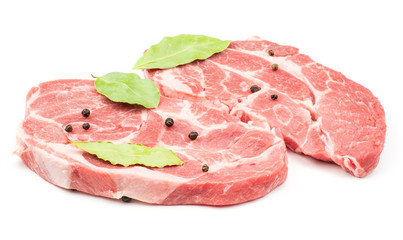 Raw pork neck meat cuts with black pepper and three bay leaves isolated on white background fresh two slices without bone .