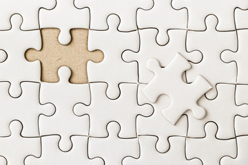 Closed up background of white plain jigsaw wait missing piece to match or fulfill