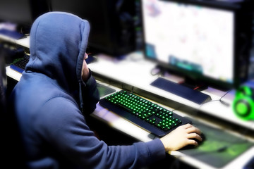 Gamer playing computer games until morning at internet cafe, game addiction concept, gamer lifestyle. © PooMtyKunG