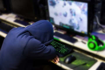 Stressed gamer while playing computer games until morning at internet cafe, game addiction concept, gamer lifestyle