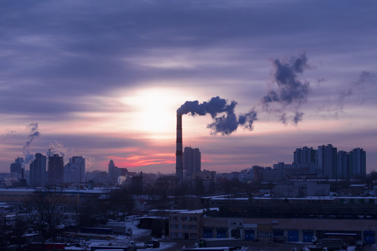 Smoke from a pipe factory against the background of the rising sun. Environmental problem of pollution of environment and air in large cities © Peter