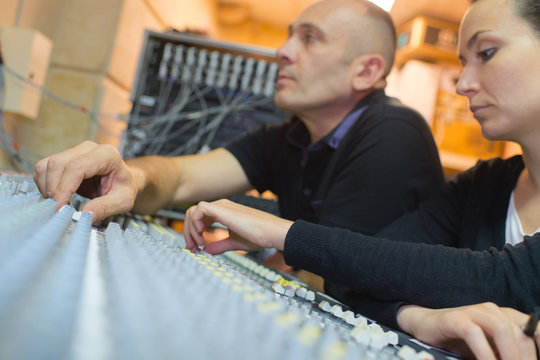 couple working at a sound mixer control panel