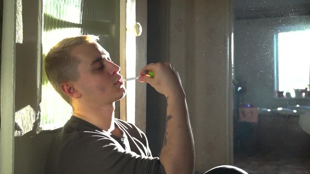 A man smokes a cigarette at home