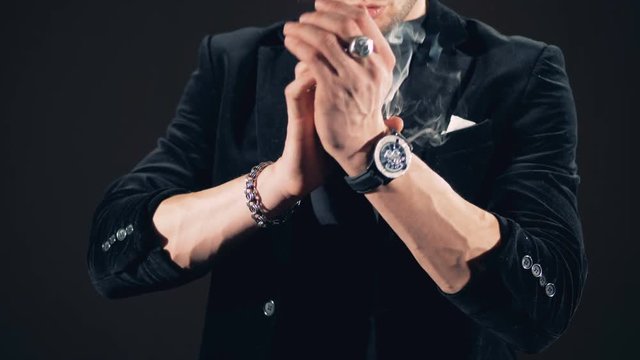 Slow motion footage of illusionist's hands producing smoke
