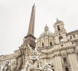 Fototapeta na wymiar the fountain of the four rivers and the facade of the church of saint agnese in piazza Navona in Rome covered with snow