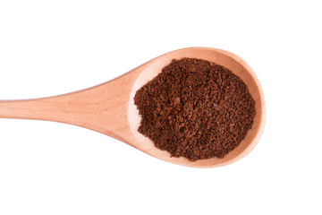 Ground coffee in a wooden spoon on a white background