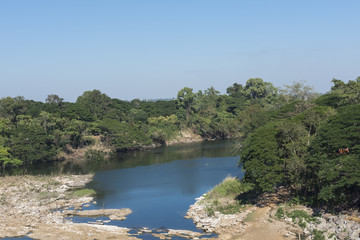 landscape behind the dam with forest and a river.