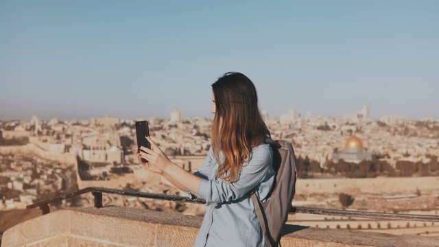 Cute tourist girl talks on video call. Jerusalem Israel. Pretty European traveler woman smiling happy and excited. 4K.