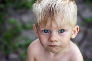 Portrait of a boy with blue eyes, a homeless child, a war child