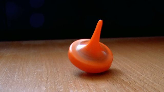 The video shows Orange spinning top spinning on the table
