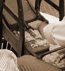 Elder carder while carding wool with sepia toned