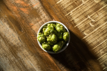 Beer brewing ingredients Hop cones in wooden bowl and wheat ears on wooden background. Beer brewery concept.