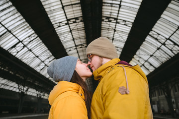 couple kissing at railway station. meet each other after long ti