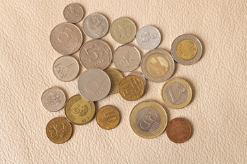 A lot of scattered coins on a leather background