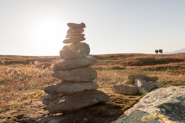 Stack of natural irregular stones in grassland with people in background