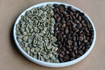 A round plate with green and roasted coffee beans divided in half on craft paper
