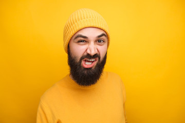 Grimacing man in yellow looking at camera