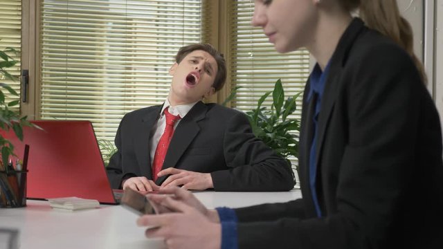 A young guy in a suit flirts with a girl in the office, howls like a wolf, humor concept. Working in the office 60 fps