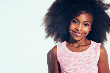 Confident young African teen standing against a white background