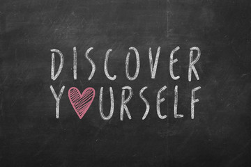 discover yourself text hand-written on black chalkboard