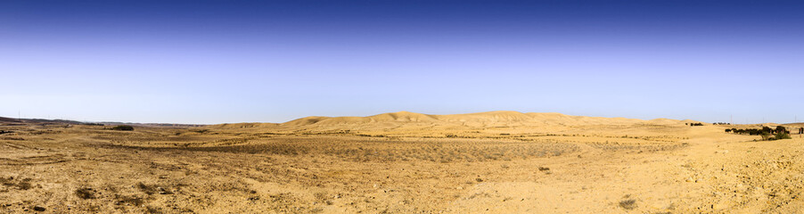 Fototapeta na wymiar Wery wide panorama of desert hills under blue sky