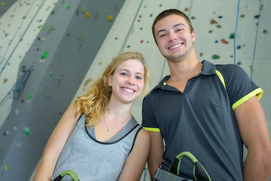Portrait of young people in front of climbing wall
