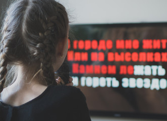 Little girl singing karaoke at home.