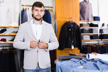 Smiling young male customer  try new jacket