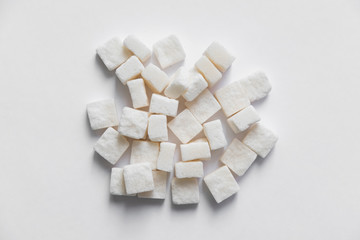 Fototapeta na wymiar pressed sugar cubes sugar refined on a textured wooden surface and on a white background isolate
