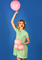 Sexy blond girl with retro makeup hold balloons.