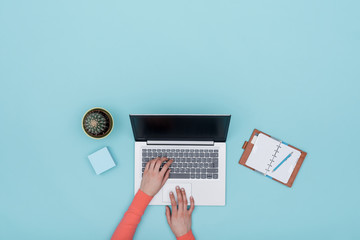 Minimalist light blue workspace with laptop