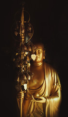Fototapeta na wymiar Golden Buddha statue with metal leaves of desires. Buddhist consciousness.