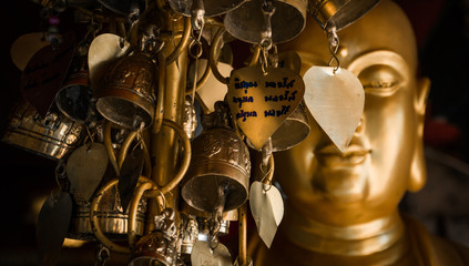 Golden Buddha statue with metal leaves of desires. Buddhist consciousness.