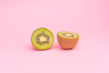 The concept of healthy eating. Half-cut kiwi on a pastel pink background.