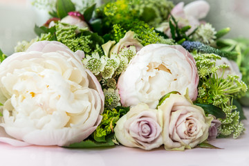 Bouquet of flowers from big peonies and pastel roses