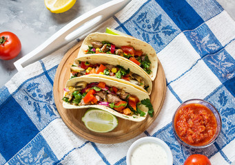 Mexican pork tacos with vegetables. Tacos al pastor on wooden blue rustic background.