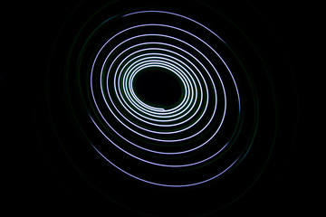 Painting with light coming from the diode. A spiral outline drawn by a flashlight suspended on a string.