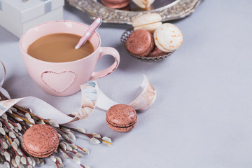 Pink coffee mug with sweet pastel french macaroons, gift box and