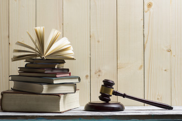 Legal Law concept - Open law book with a wooden judges gavel on table in a courtroom or law enforcement office. Copy space for text